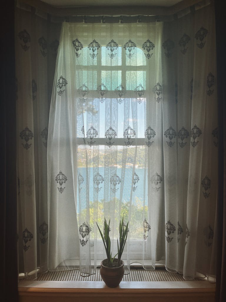 Delicate lace curtains provide filtered light patterns.