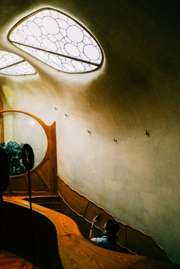 A room with a bed and a mirror in it Casa Batlló